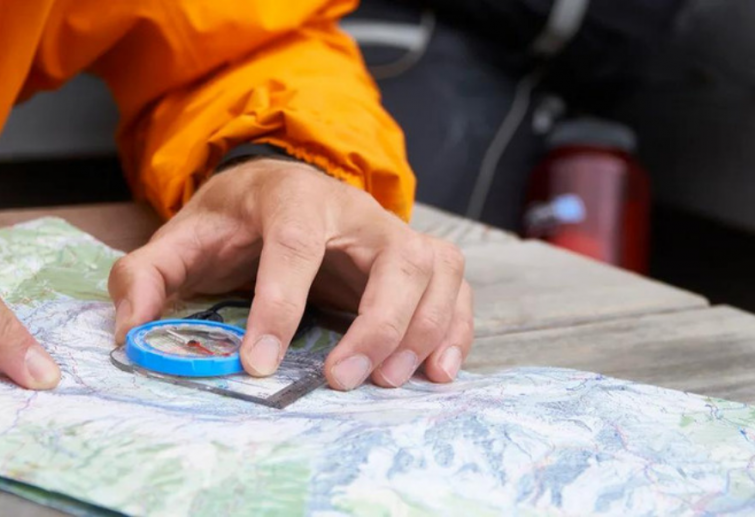 A hiker using a compass